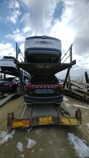 Чёрный Haval на автовозе, вид сзади; другие автомобили присутствуют в кадре
